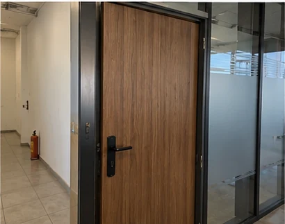 Interior door finished in a wood effect beside a frosted glass partition