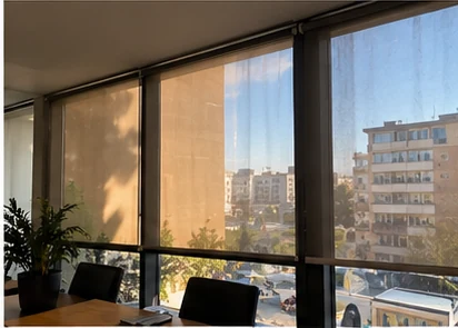 Low sun coming through the window wall of an office, across the desk