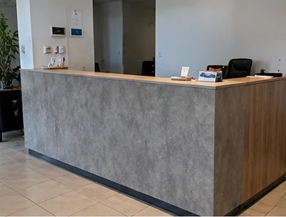 Reception desk with a stone-effect front and a wood-effect side panel